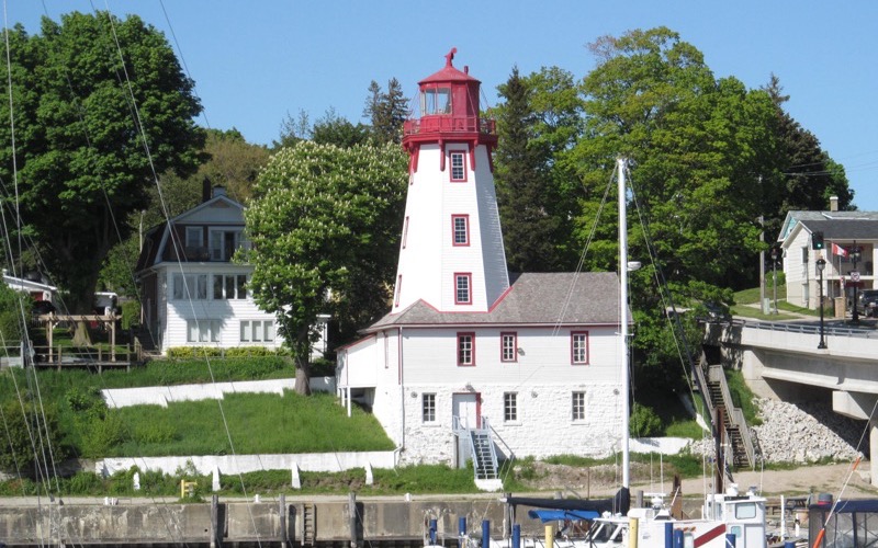 Kincardine Lighthouse beside the harbour with boats and trees